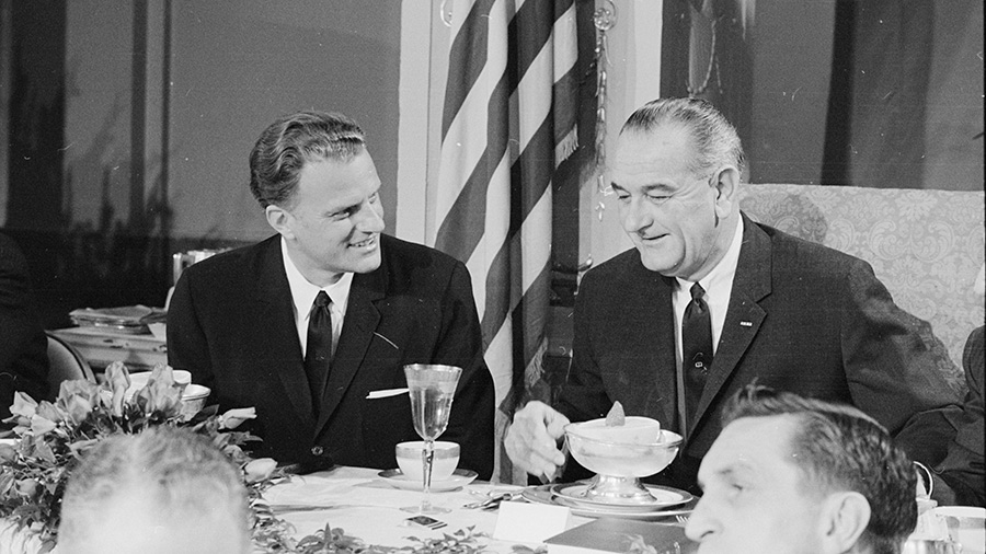 American evangelist Billy Graham and US President Lyndon B Johnson talk together at the Annual Presidential Prayer Breakfast, Washington DC, February 5, 1964. 