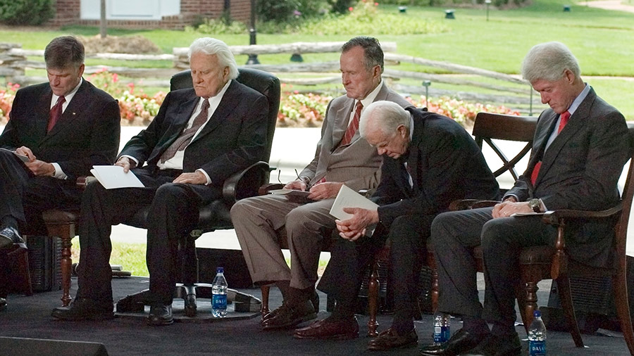 Franklin Graham, Billy Graham, and former U.S. Presidents George H. W. Bush, Jimmy Carter and Bill Clinton bow their heads in prayer during the Billy Graham Library Dedication Service on May 31, 2007 in Charlotte, North Carolina.