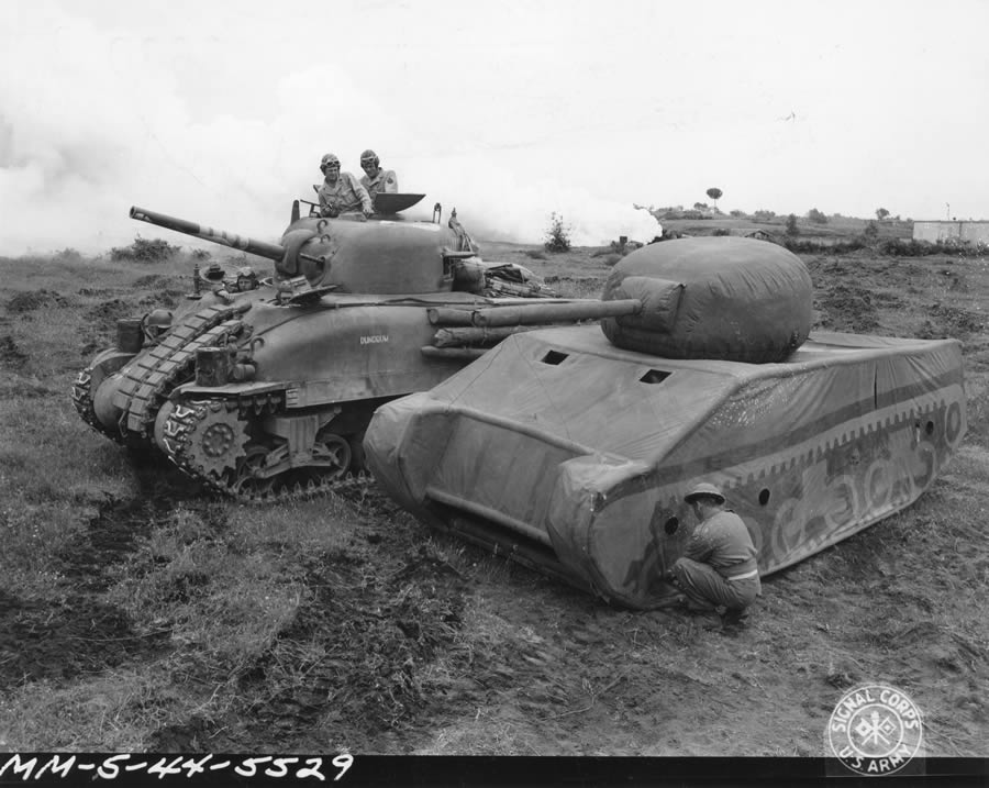 5/20/1944 — Original Caption: Dummy tank designed by British, made of rubber and inflated when used, can be assembled in 20 minutes. When used in field can simulate tank positions. Comparison between United States Army medium tank, Mark IV, and the completely inflated and assembled dummy which is slightly smaller. Photo by Gallagher, 163rd Signal Photo Company