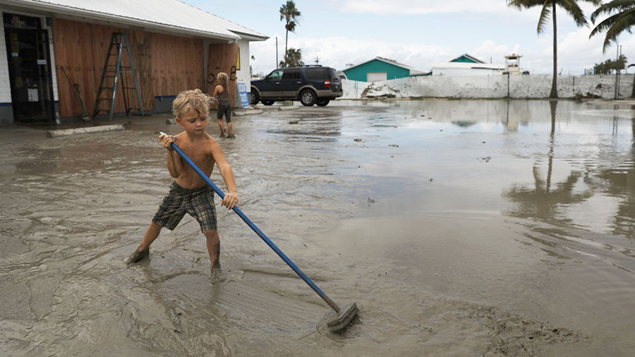 A child plays at his family's flooded gas station in the heavily damaged town of Everglades City the day after Hurricane Irma swept through the area on September 11, 2017 in Everglades City, Florida. 