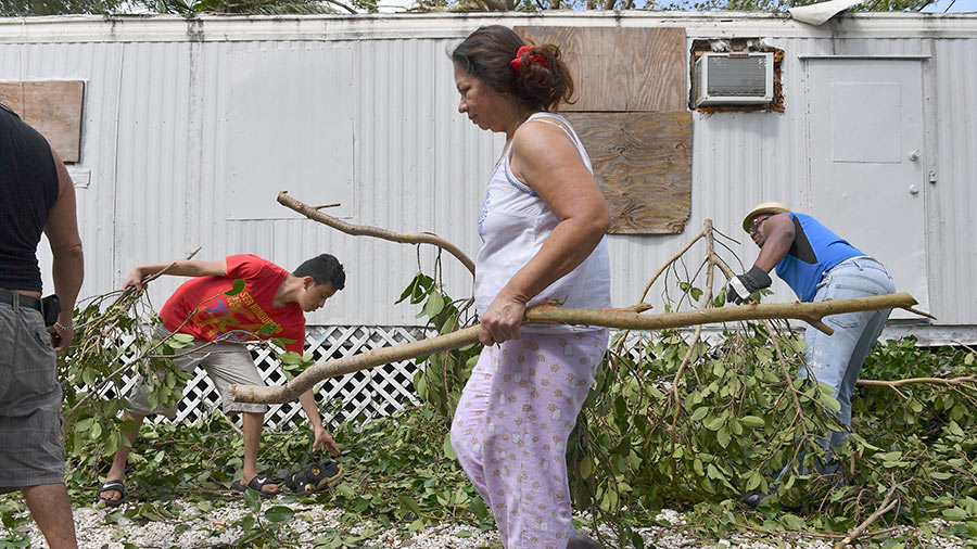  Marta Izaguirre, center, along with her neighbors pick up debris during clean-up efforts from Hurricane Irma in the Royal Duke Trailer Park on September 11, 2017 in Miami, Fl. 