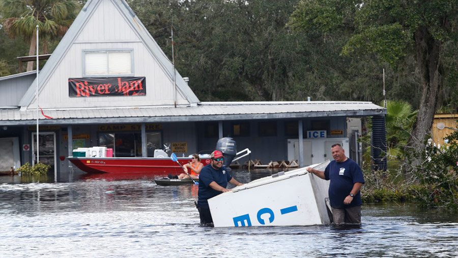 A crew works to salvage items, including an ice machine, as water from the nearby Peace River floods the Peace River Campground in the wake of Hurricane Irma on September 12, 2017 in Arcadia, Florida.