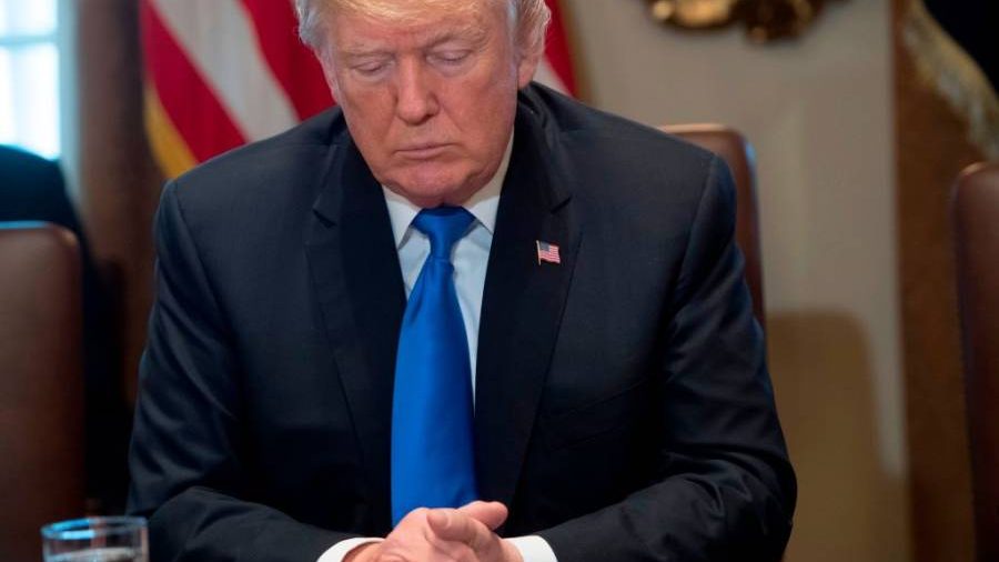 US President Donald Trump bows his head during a prayer as he holds a Cabinet Meeting in the Cabinet Room at the White House in Washington, DC, December 20, 2017. / AFP PHOTO / SAUL LOEB (Photo credit should read SAUL LOEB/AFP/Getty Images)