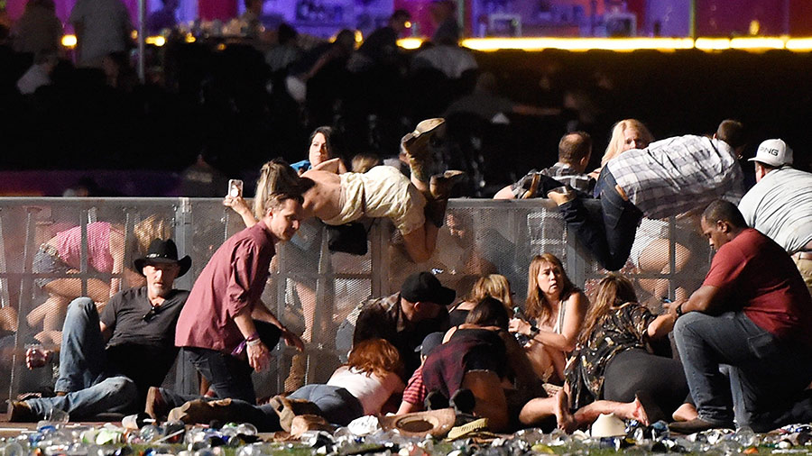 People scramble for shelter at the Route 91 Harvest country music festival after gun fire was heard on October 1, 2017 in Las Vegas, Nevada.