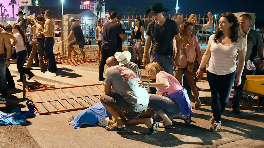 People tend to the wounded outside the Route 91 Harvest Country music festival grounds after a shooting on October 1, 2017 in Las Vegas, Nevada. 