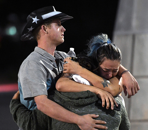 People hug and cry outside the Thomas & Mack Center after a mass shooting at the Route 91 Harvest country music festival on October 2, 2017 in Las Vegas, Nevada. A gunman, identified as Stephen Paddock, 64, of Mesquite, Nevada, opened fire from the Mandalay Bay Resort and Casino on the music festival, leaving at least 50 people dead and hundreds injured. 